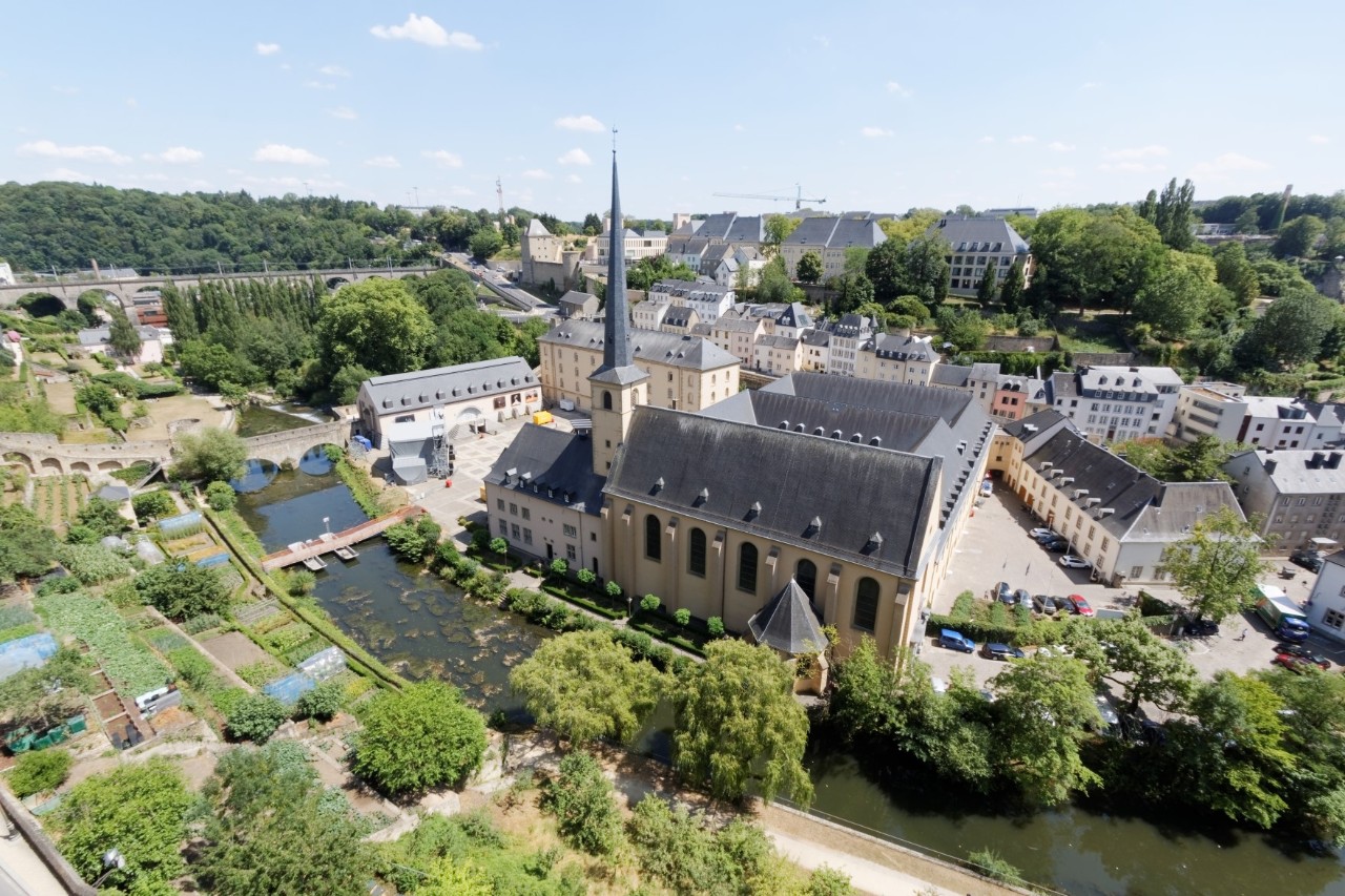 View from above of the Benedictine abbey on the Alzette River surrounded by trees and buildings 