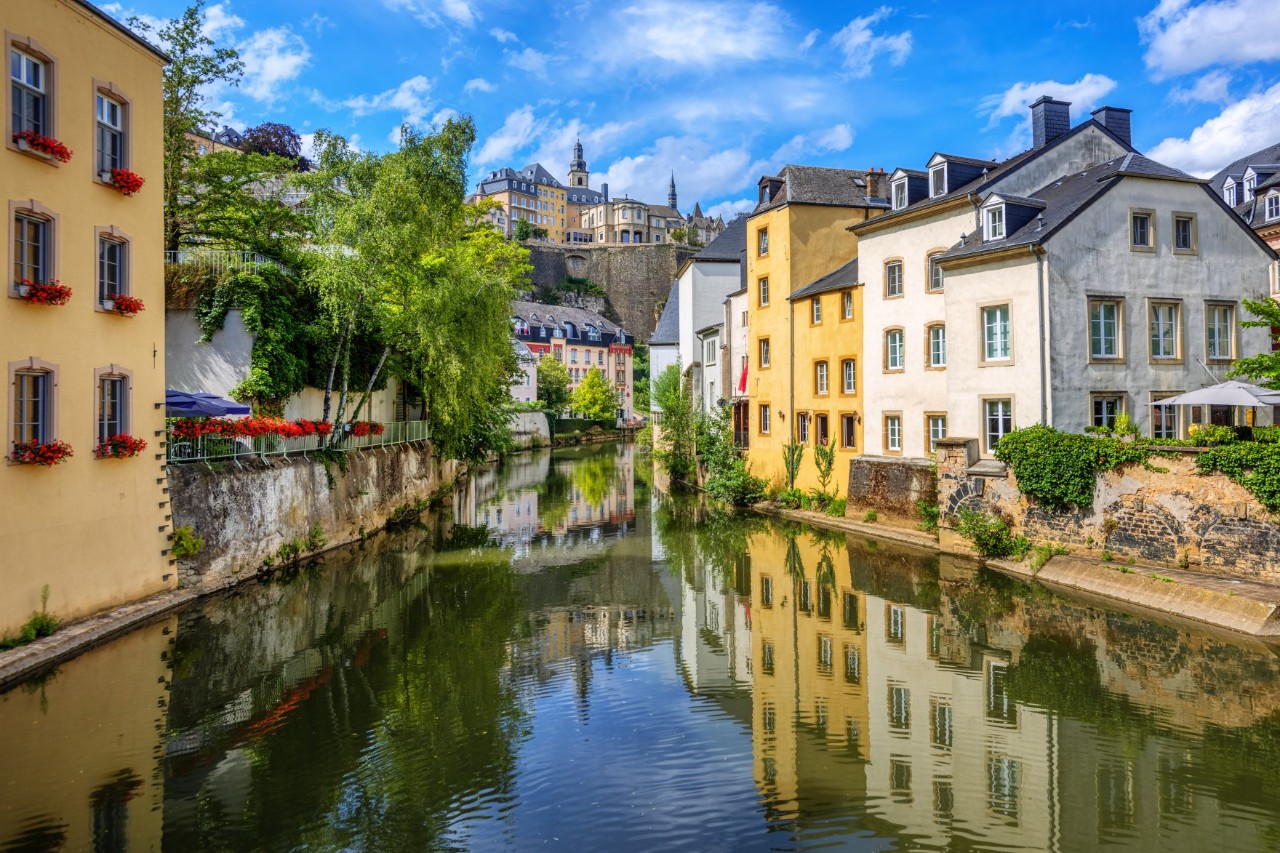 The Alzette River surrounded by buildings, trees and walls, with a view of the Upper Town © Boris Stroujko/stock.adobe.com 