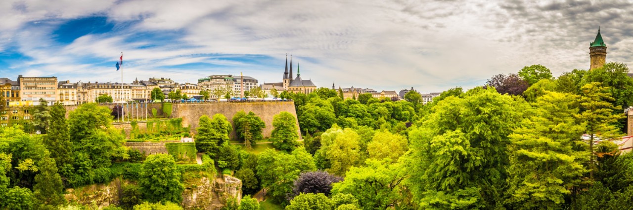 Panoramic view of Luxembourg City with fortress, buildings, church towers and lots of greenery. © powell83/stock.adobe.com