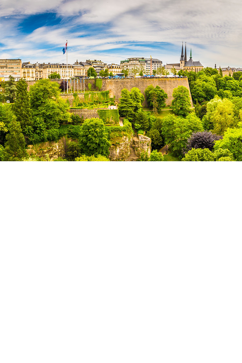Panoramic view of Luxembourg City with fortress, buildings, church towers and lots of greenery. © powell83/stock.adobe.com