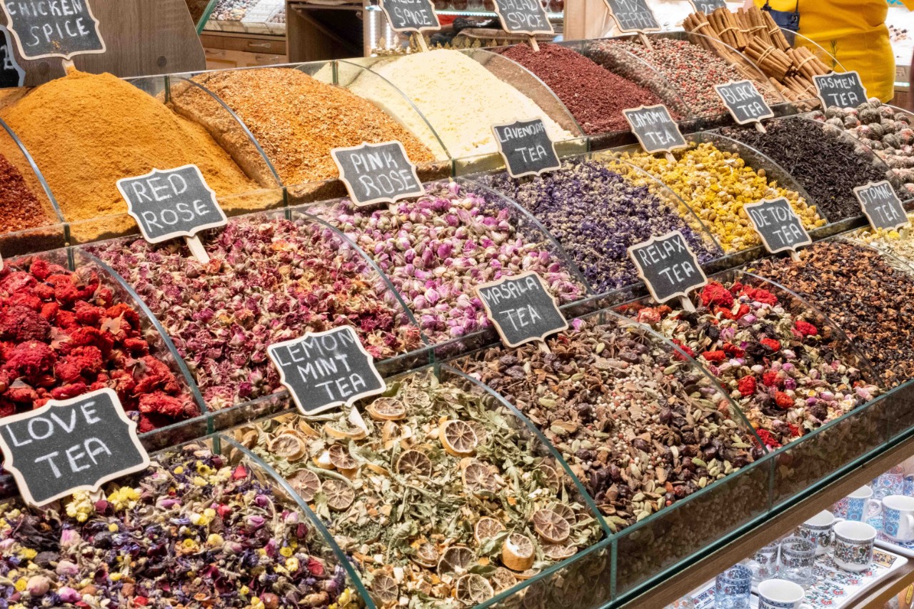  Colorful display of spices and teas in open containers.
