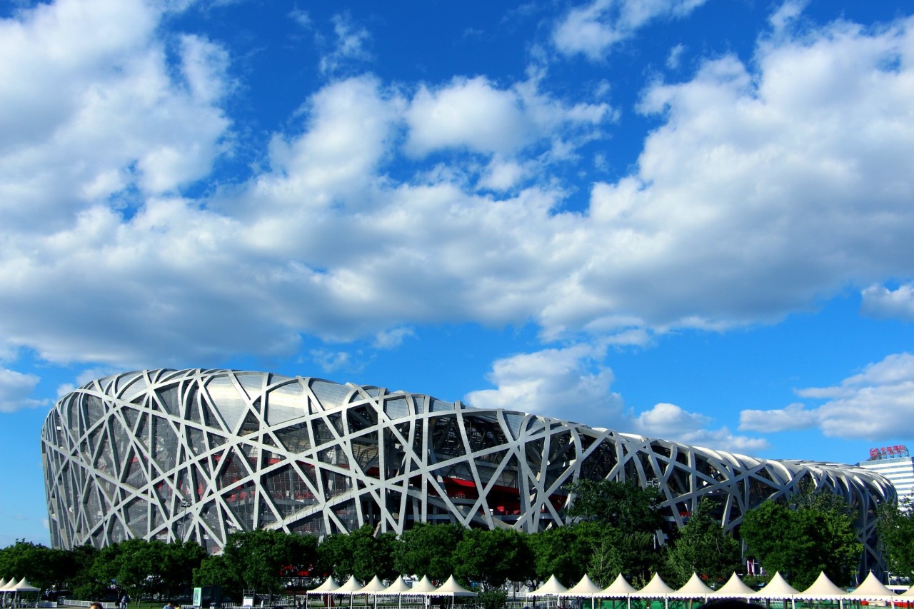 National Stadium in Beijing with iconic nest structure at dusk.
