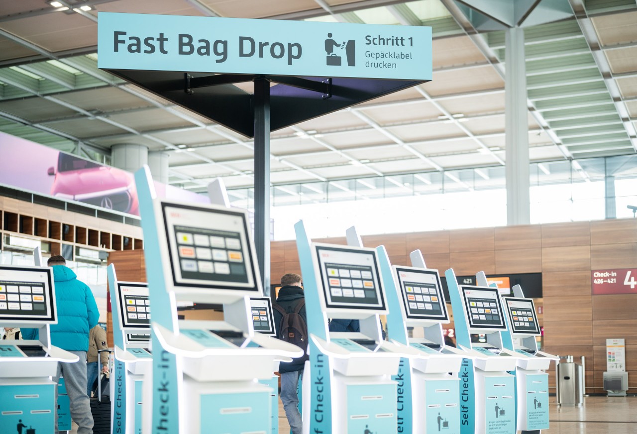 Turquoise kiosks. Self-service counters in the background.