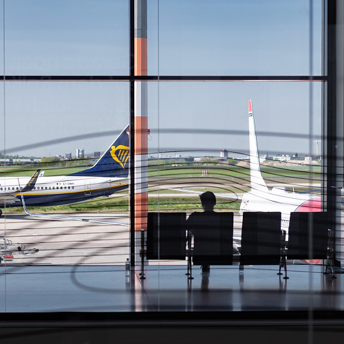 A person is sitting in the North Pier, with the apron and two airplanes visible behind them.