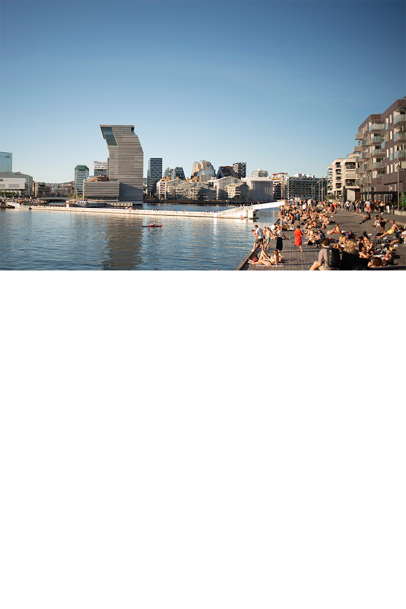 Modern buildings in Oslo by the water, some with glass facades.