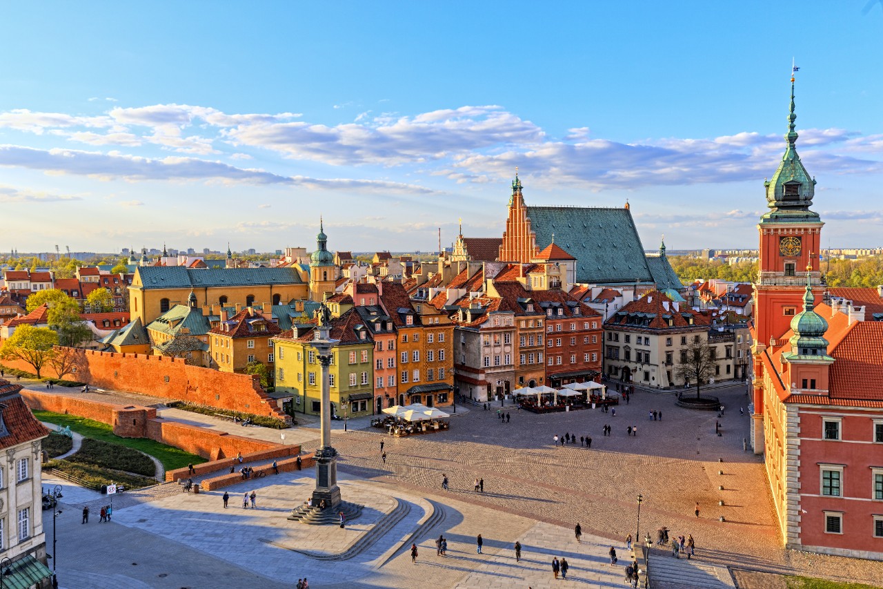 Market square in Warsaw with historic houses in warm evening light.