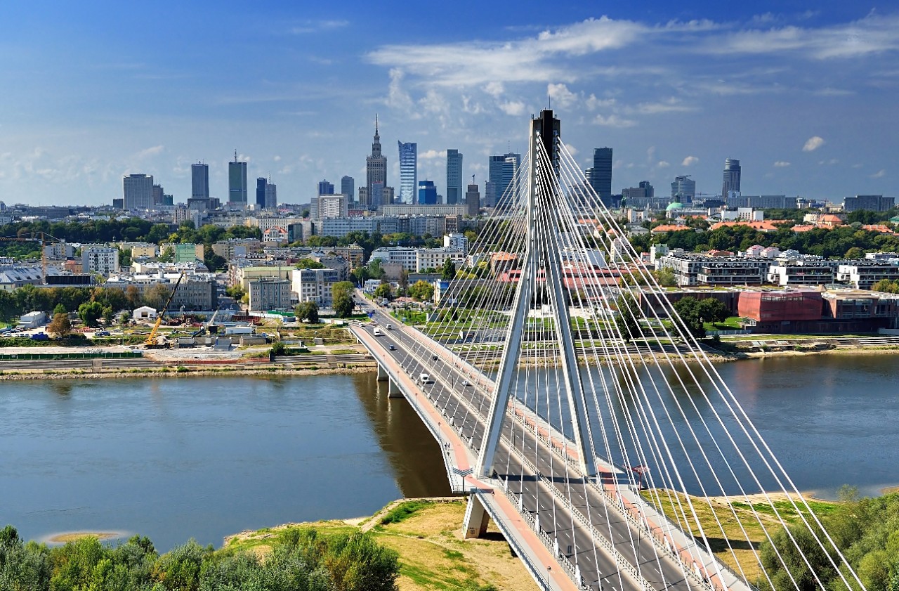 Aerial view of Warsaw's Vistula river with modern cable-stayed bridge.