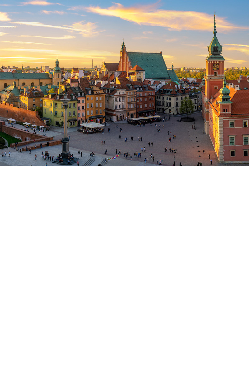 Market square in Warsaw with historic houses in warm evening light.