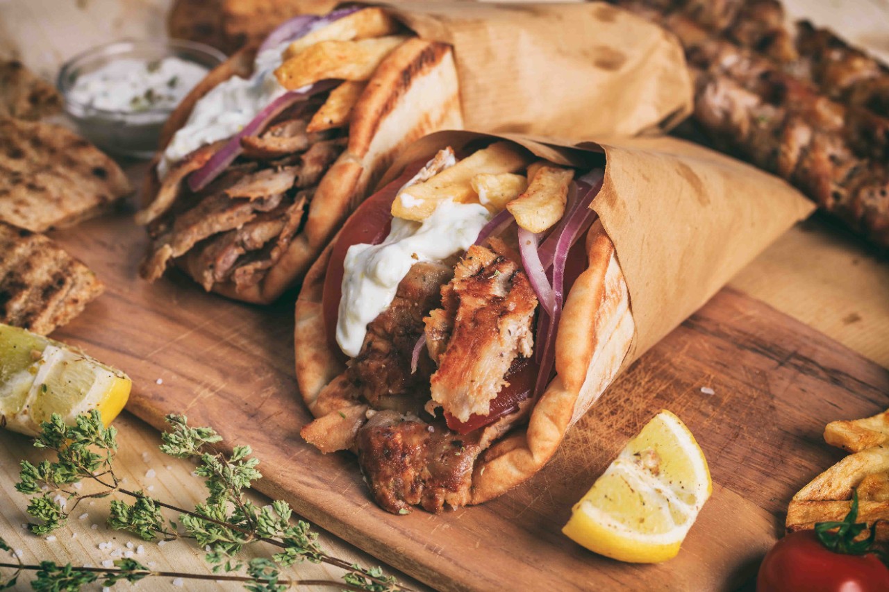 Souvlaki pita with chicken gyros, tomatoes, and onions served.