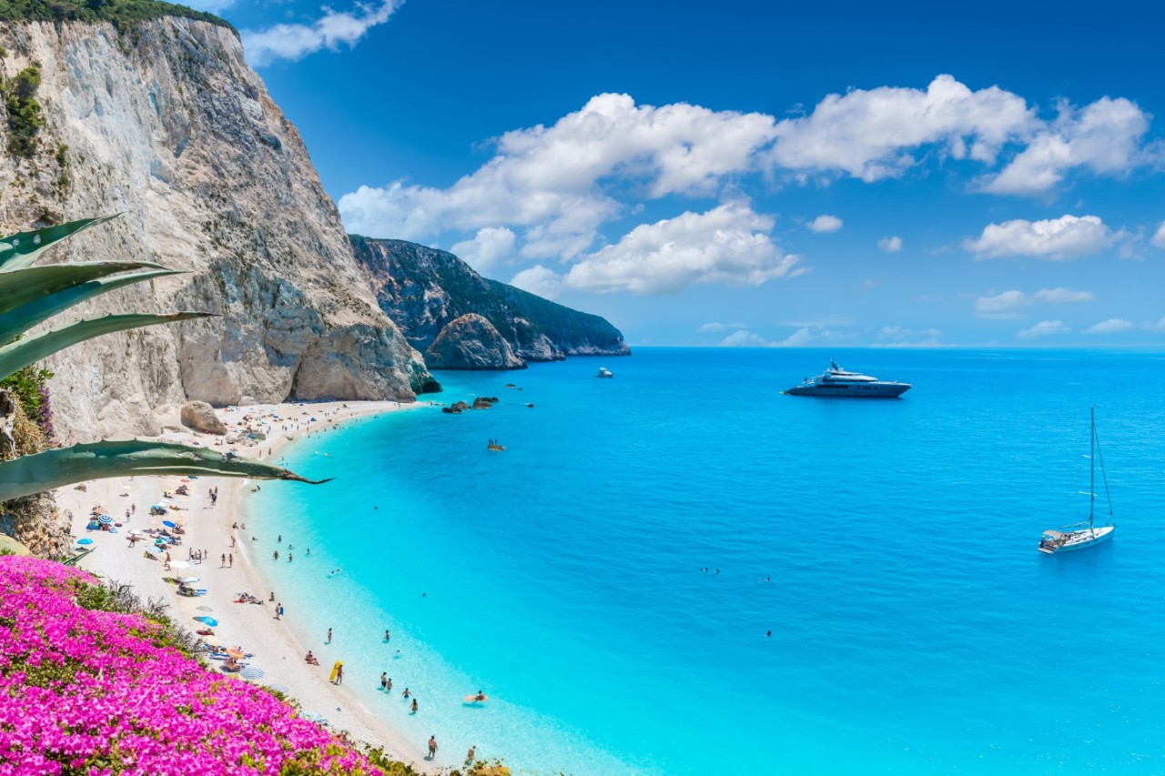 White cliff beach, turquoise sea, and luxury yacht.