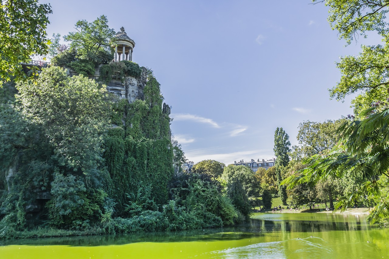 Parc des Buttes-Chaumont with lake, temple, and view of Sacré-Cœur.