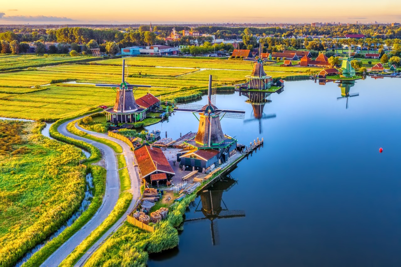 Traditional windmills by the water at the Zaanse Schans open-air museum.
