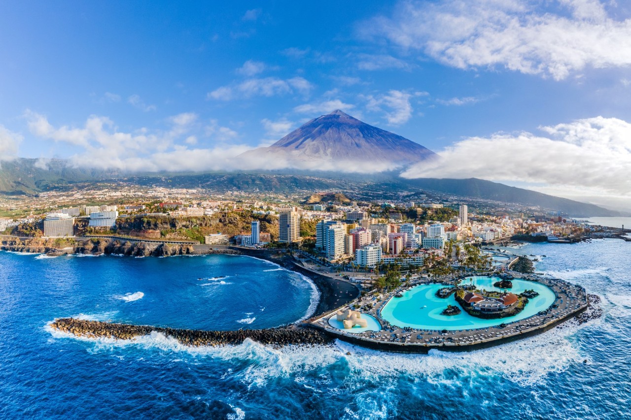 The city of Puerto de la Cruz, in the background you can see the mountain Pico del Teide, sea, coastal landscape 