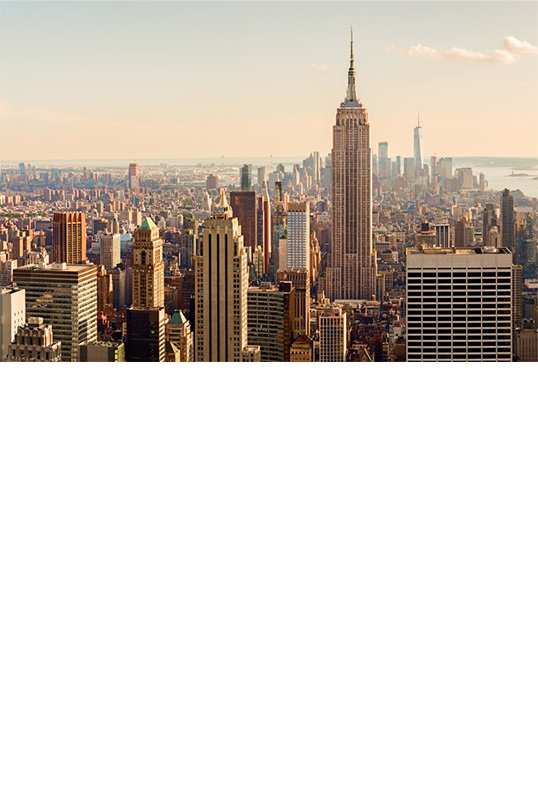 New York City skyline in warm evening light with glowing buildings.