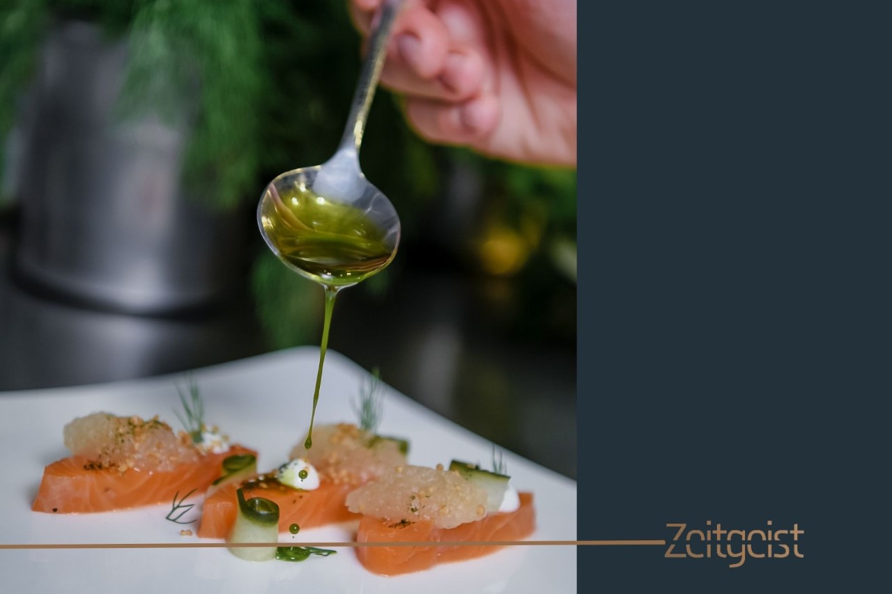 A plate with salmon, spices and an olive oil garnish.