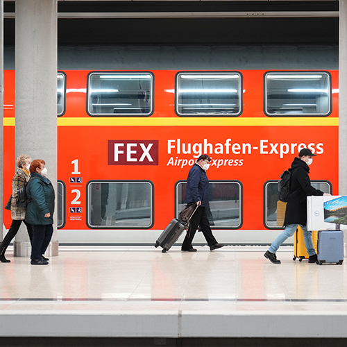 FEX Zug im BER-Bahnof. Davor Menschen auf dem Bahnsteig