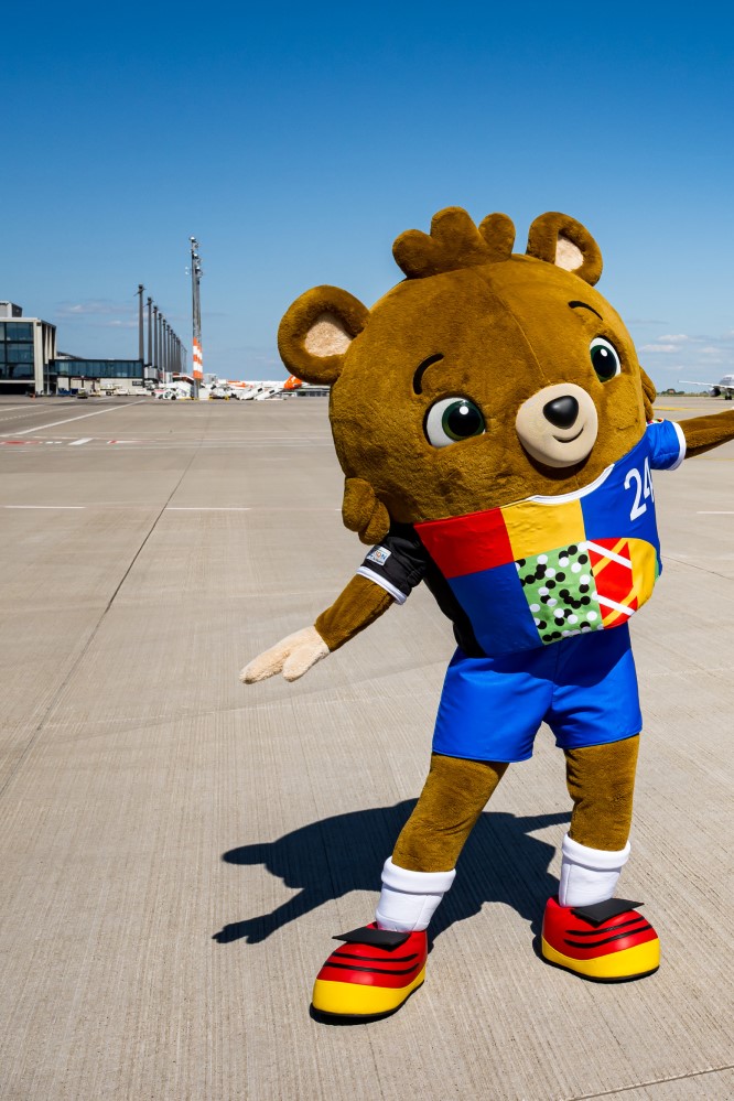 Albärt the EM mascot on the BER apron. Behind it is Terminal 1.