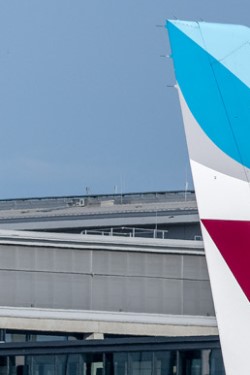 Close-up of the tail of a Eurowings aircraft in front of BER Terminal 1