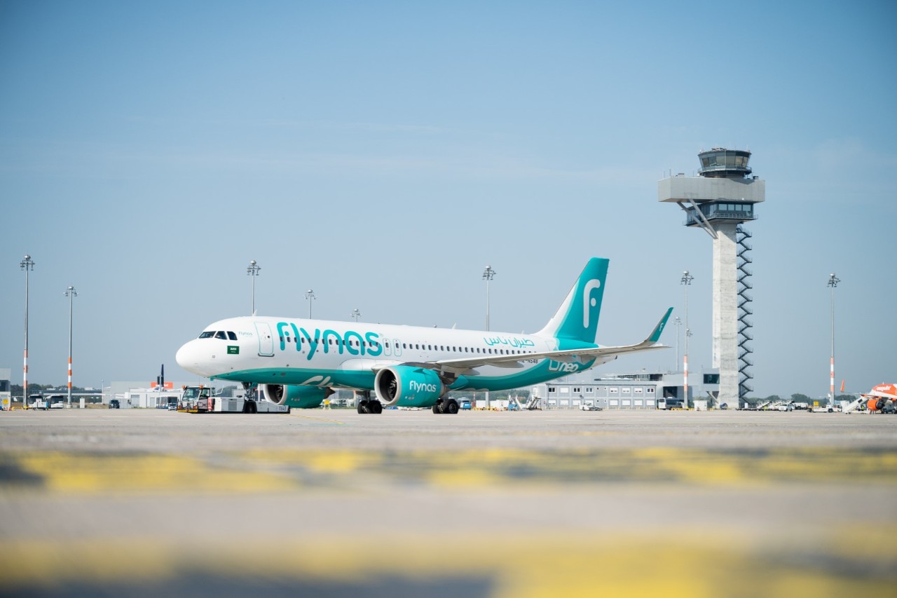 Aircraft of the airline flynas at BER. The tower in the background.