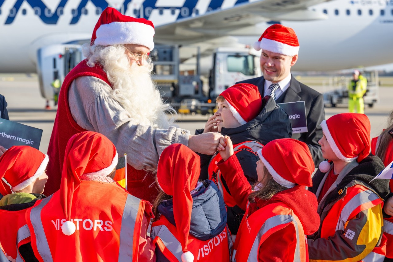 Santa Claus with a group of children in front of an aeroplane