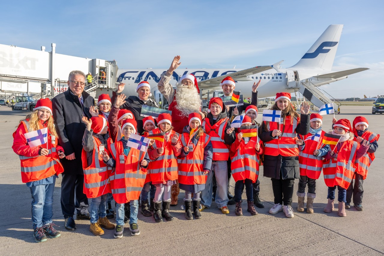 Santa Claus with a group of children and adults in front of an aeroplane