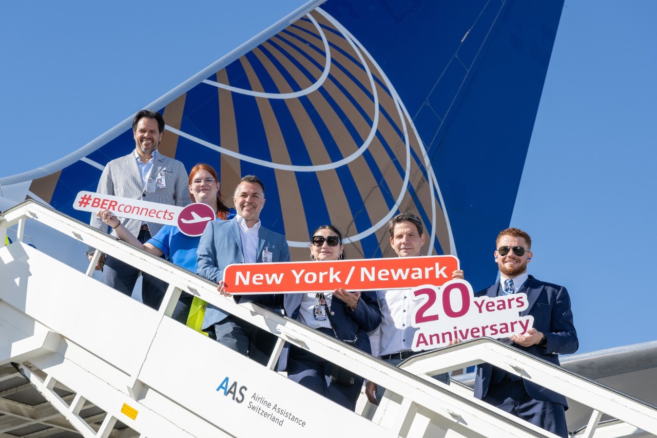 A group of people on the steps leading up to an aircraft. They are holding signs in their hands.