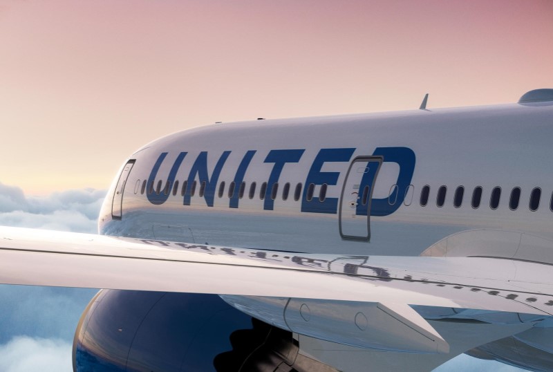 An exterior view of part of an aircraft in flight. Visible are a wing with an engine and the word ‘UNITED’.