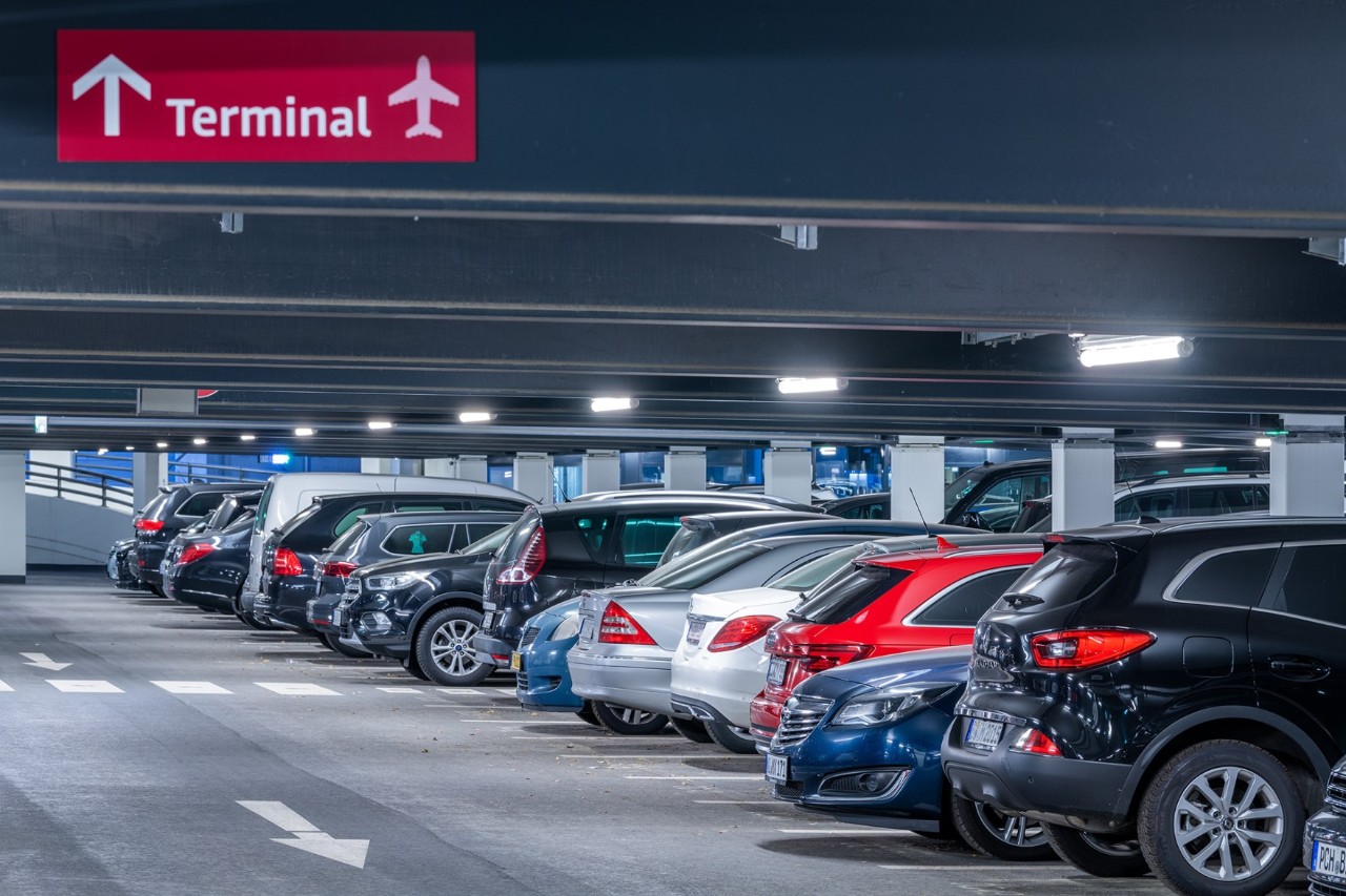 Inside the parking garage: numerous cars and directional signs to the terminal.