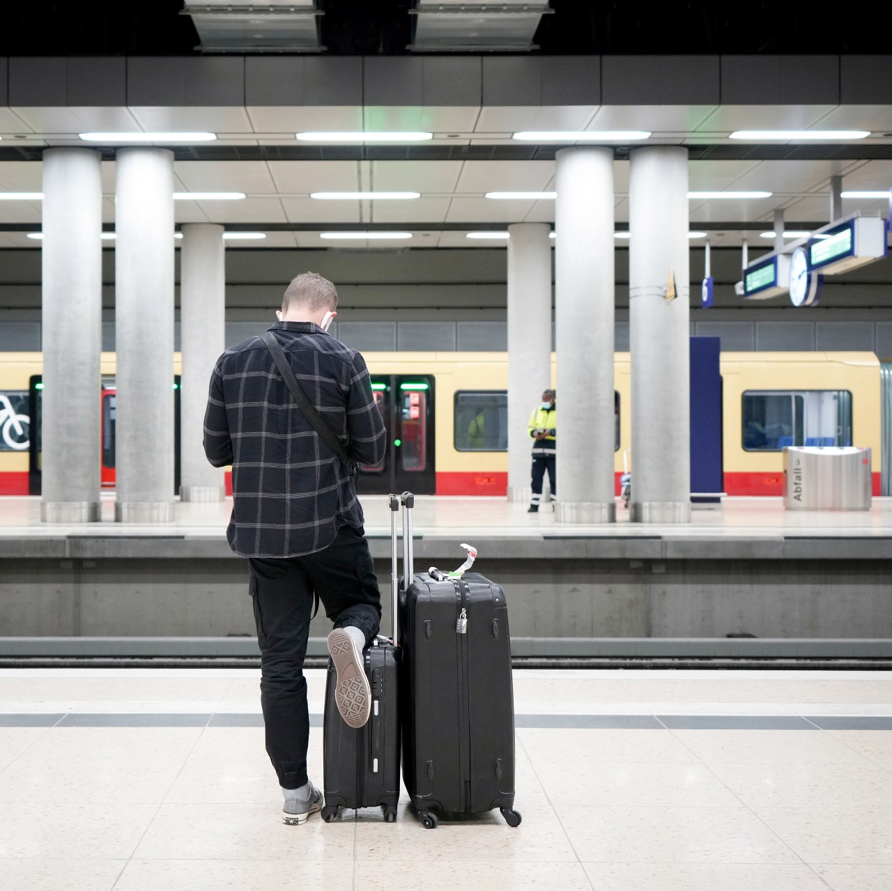 Person standing on the track, a suburban train behind them