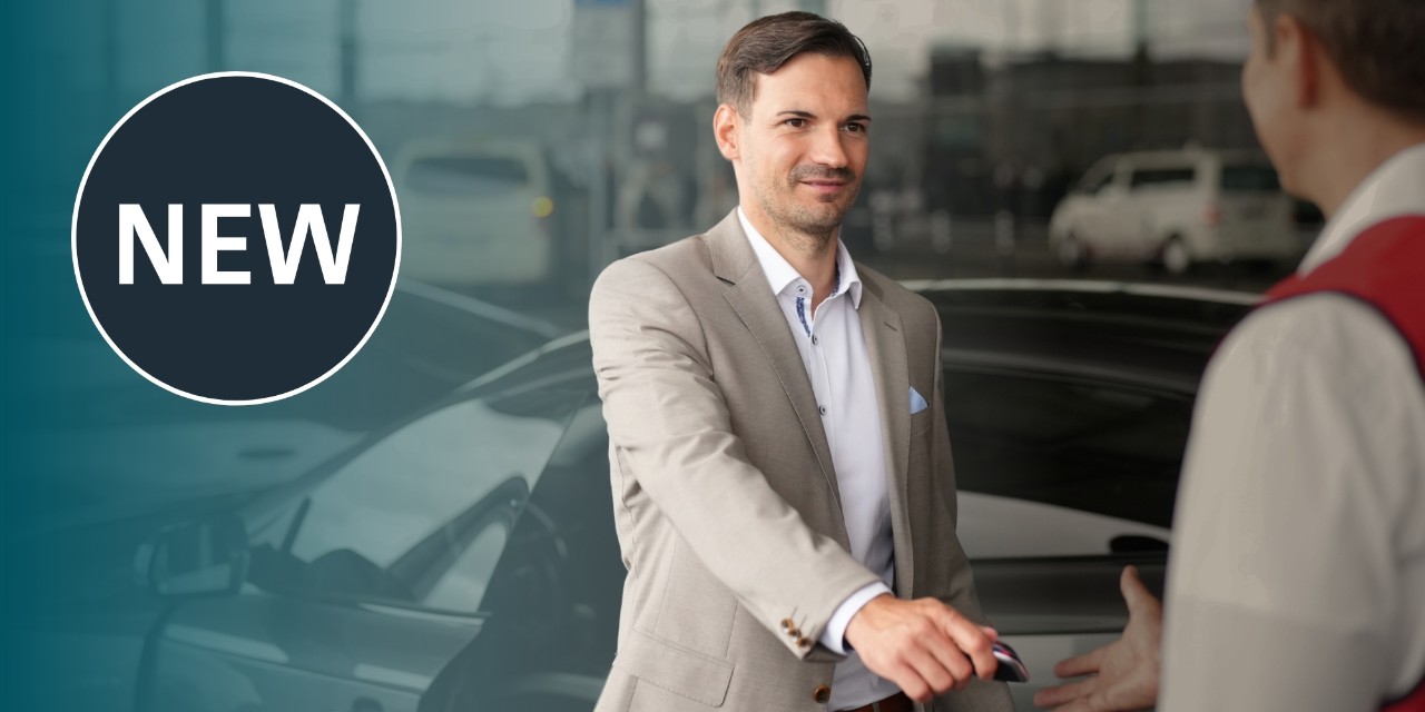 Man hands over his car key to valet employee in front of Terminal 1, informing him that this is a new service that can be booked.