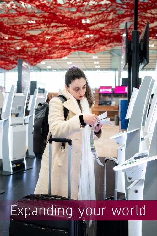 A person at the self-check-in counter in an airport terminal