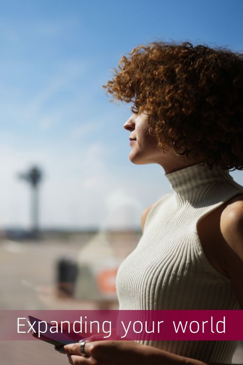 Passenger standing at a window pane in an airport building