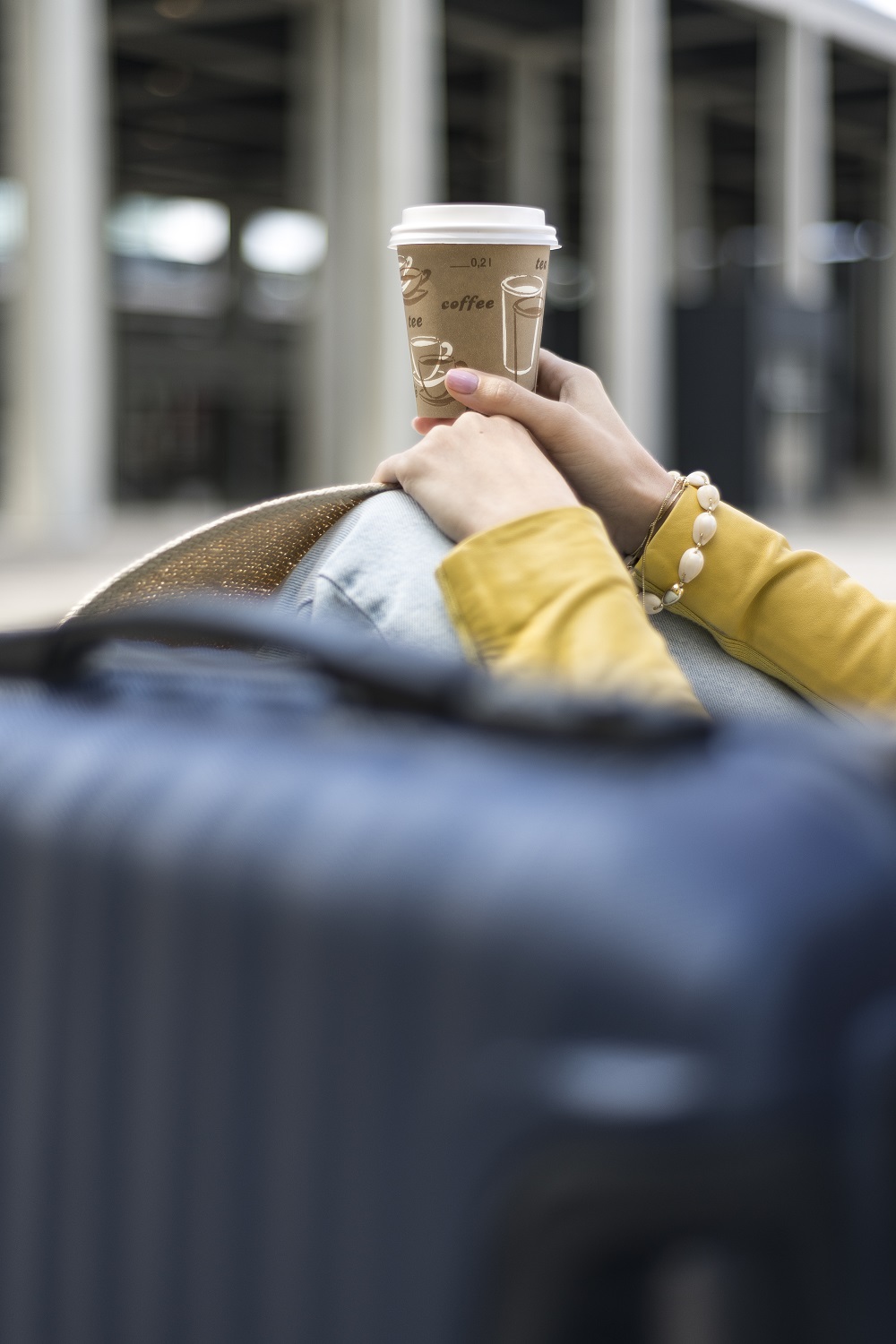 Woman with a coffee in front of the terminal